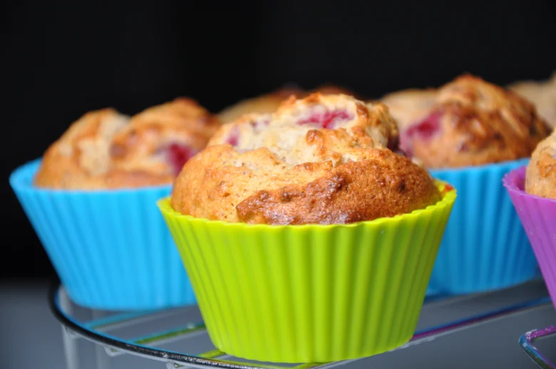 Bezlepkové muffiny v barevných silikonových formách na mřížce.