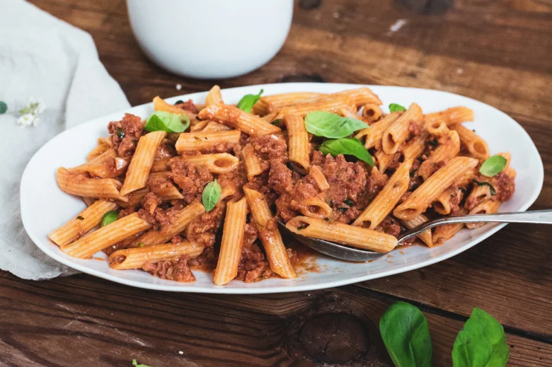 Penne s mletým masem a bazalkou na talíři