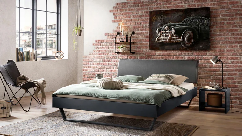 Loft stylizace s cihlovou zdí a tmavým postelem