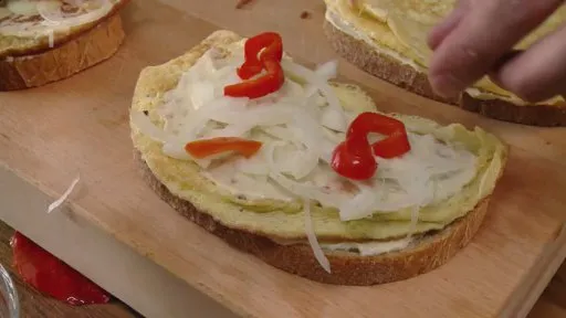 Příprava chleba s cibulí a červeným pepřem pro smaženku.