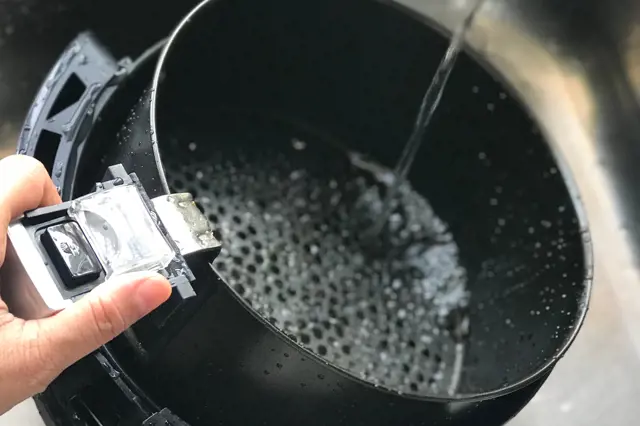 Čistění košíku horkovzdušné fritézy pod tekoucí vodou