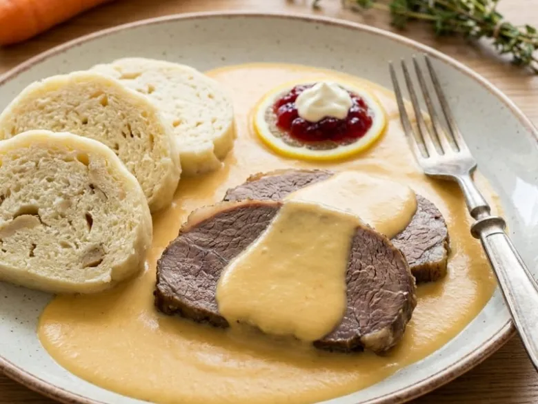 Připravená svíčková s knödly, omáčkou a brusinkovou marmeládou.