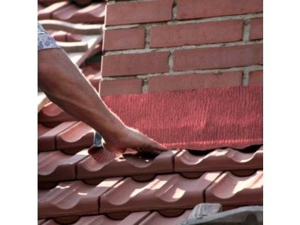 Instalace ochranného oplechování na komín s cihlovou zdí.