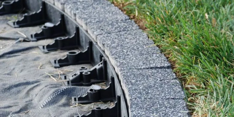 Instalace opěrné zdi s plastovými hranicemi a betonovými bloky