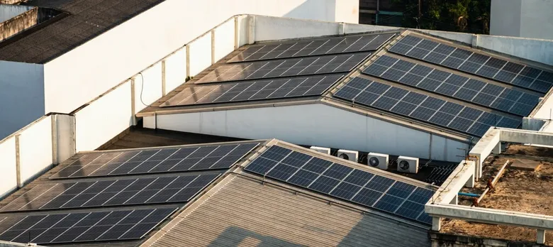 Fotovoltaické panely na střeše budovy pro výrobu sluneční energie.