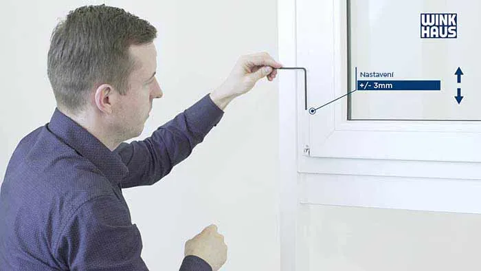 Muž nastavuje okení mechanismus pomocí nástroje.