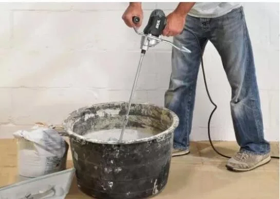 Míchání izolační maltu elektrickým mixérem v kbelíku.