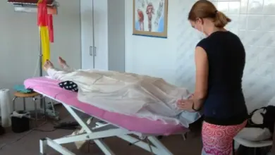 Žena dostává péči po porodu v ordinaci s asistencí zdravotní sestry.