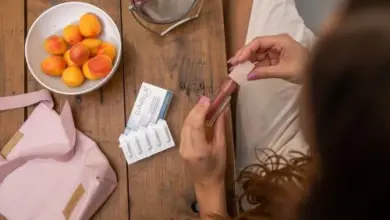 Žena používá kosmetiku s ovocem na stole, nevhodné pro svědění pochvy.