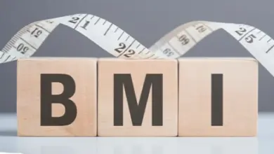 Dřevěné kostky s písmeny BMI a metr pro výpočet indexu tělesné hmotnosti.