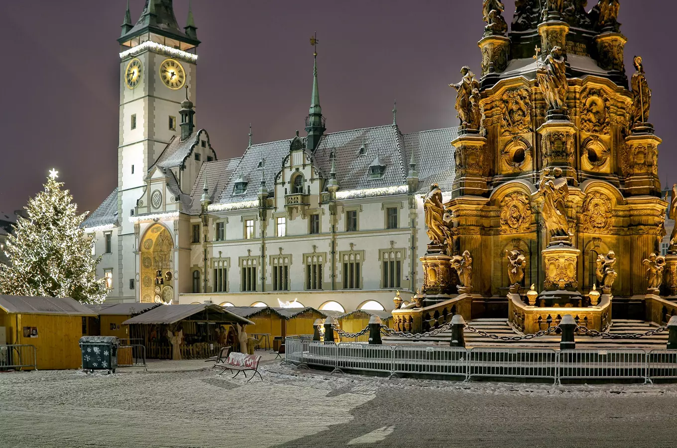 Vánoční trh v olomouckém náměstí s fontánou a budovou radnice.