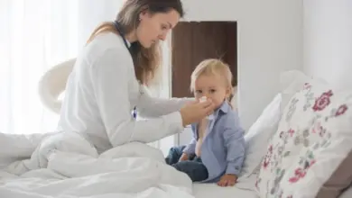 Lékařka čistí nos dítěti v posteli