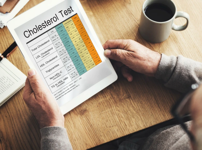 Starší člověk sleduje výsledky testu cholesterolu na tabletu.