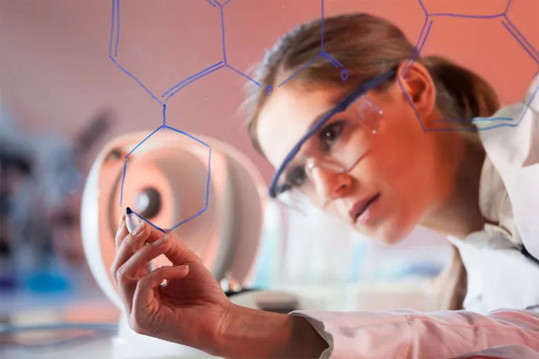 Vědkyně kreslí chemické struktury na interaktivní obrazovku v laboratoři.