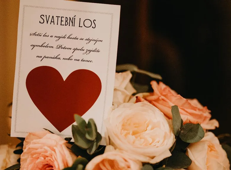 Karta svatební hry s červeným srdcem mezi růžemi