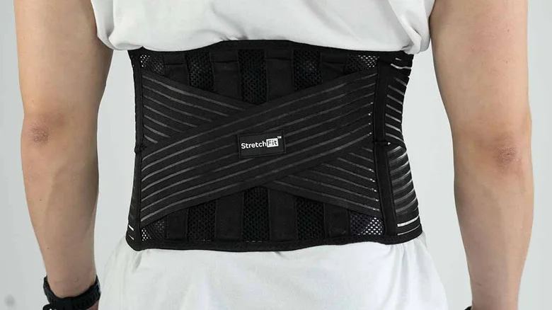 Černý opěrný pás pro záda na bílém oblečení.