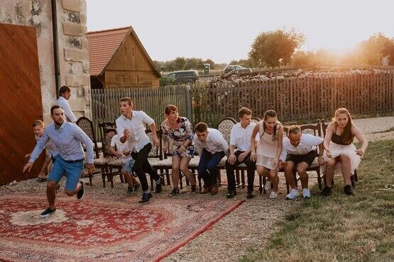 Svatba: hosté hrají hry s židlemi venku.